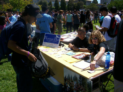 Students sitting at a signup table on Memorial Glade